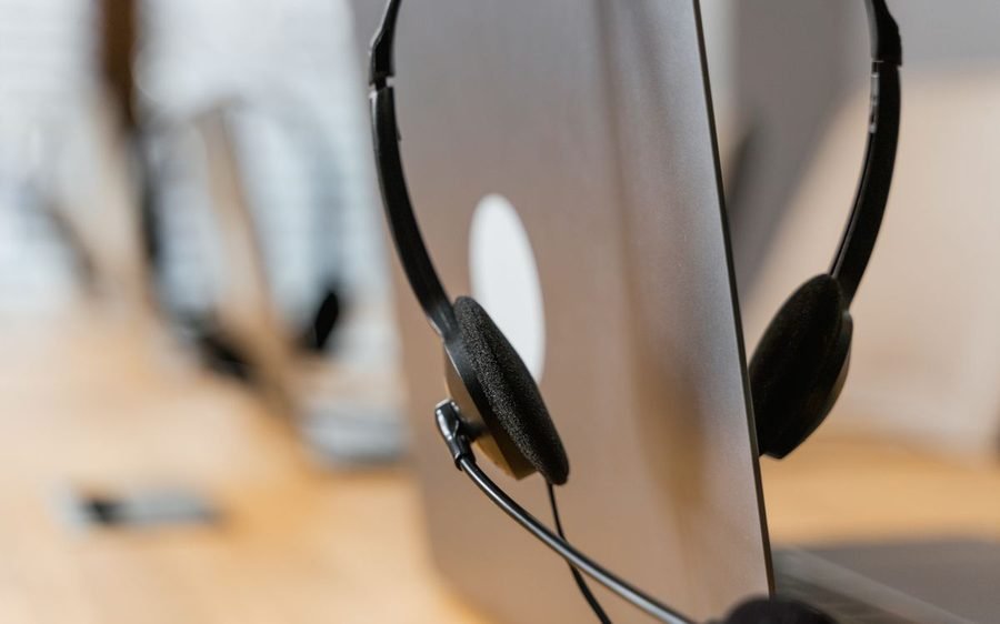 Headset resting on a laptop at a support desk